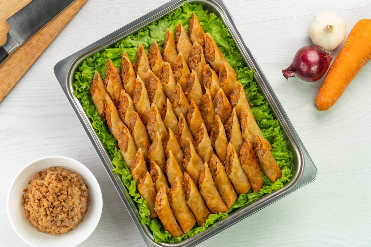 Argentina Giniling lumpiang shanghai in a food service tray, plated on lettuce with a side of dip, made with Argentina Ready-to-Use Giniling