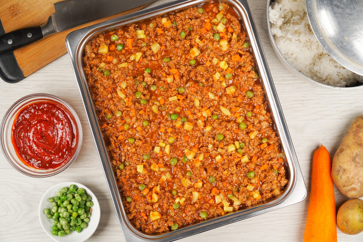 Argentina red giniling in a food service tray with peas and carrots, served with ketchup on the side